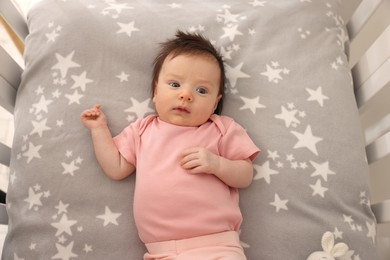 Photo of Getting ready for bed. Cute little baby lying in crib, top view