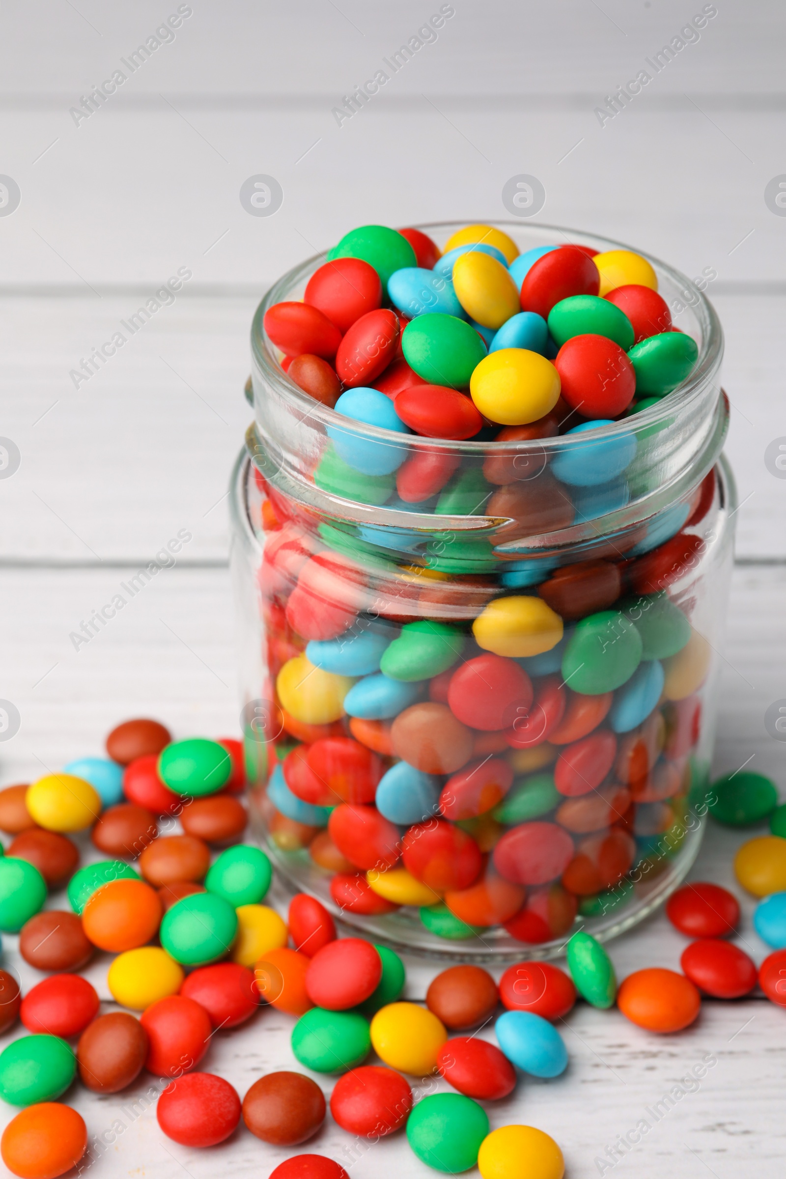 Photo of Tasty colorful candies on white wooden table, closeup