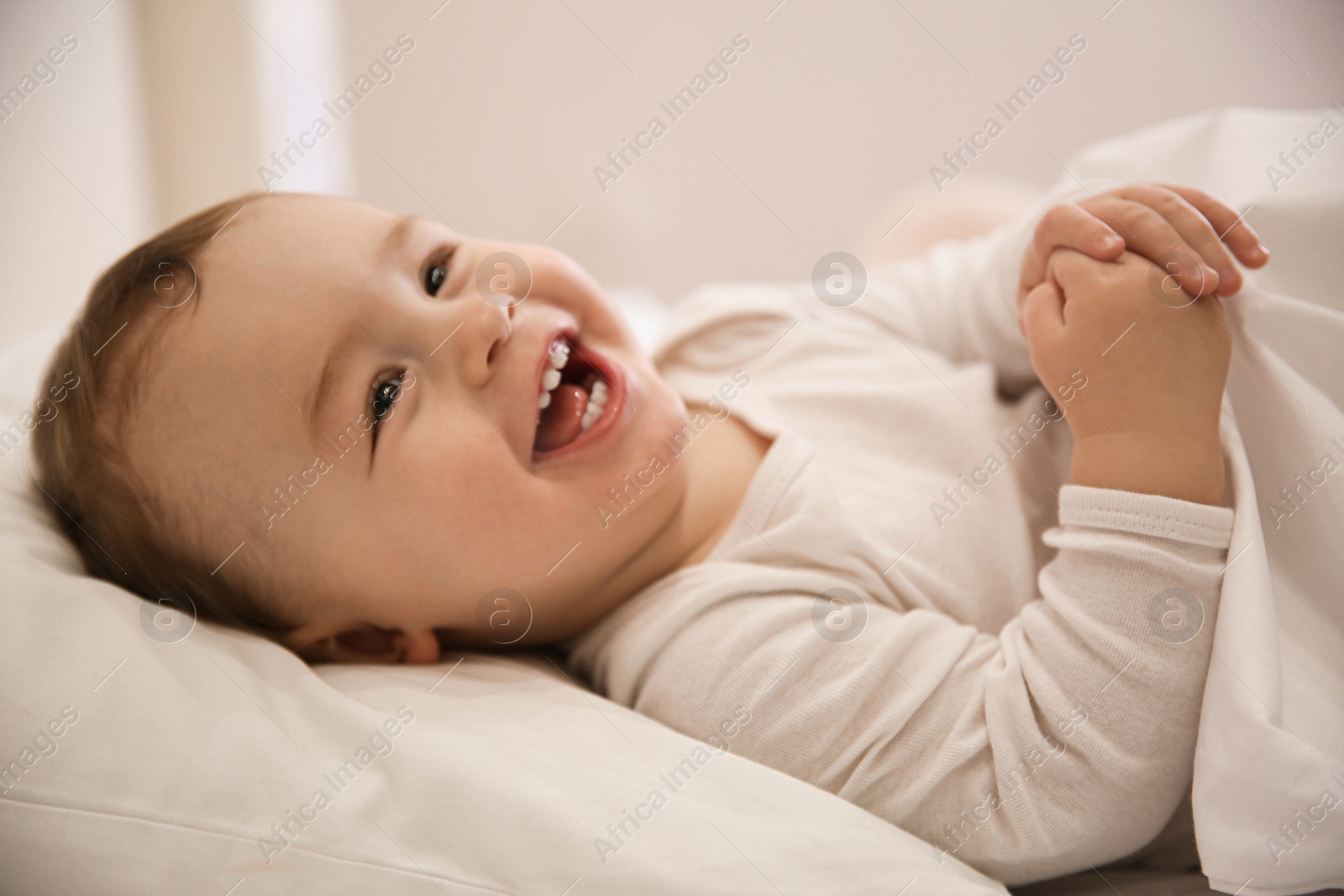 Photo of Cute little baby lying in comfortable crib. Bedtime