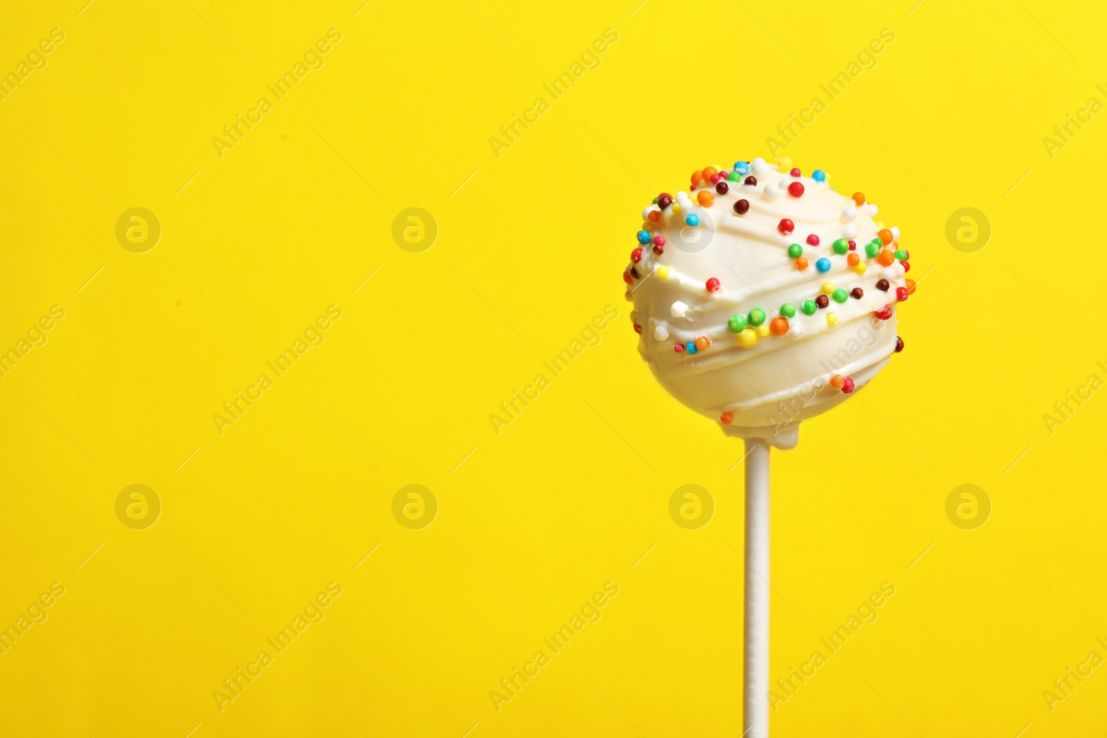 Photo of Bright delicious cake pop on color background. Space for text