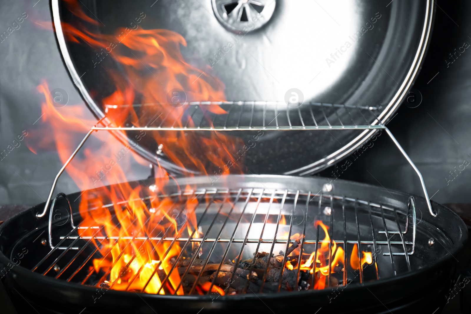 Photo of New modern barbecue grill with coals on black background