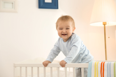 Cute little baby in crib at home