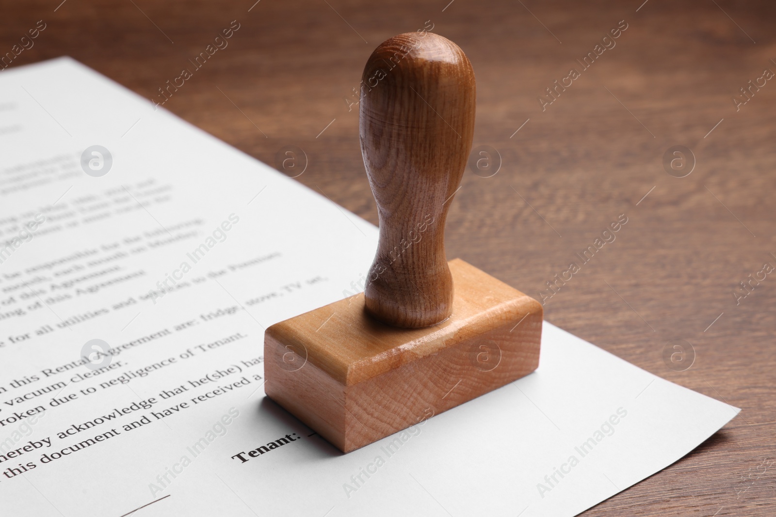 Photo of One stamp tool and document on wooden table, closeup