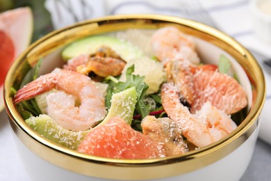 Delicious pomelo salad with shrimps on table, closeup view