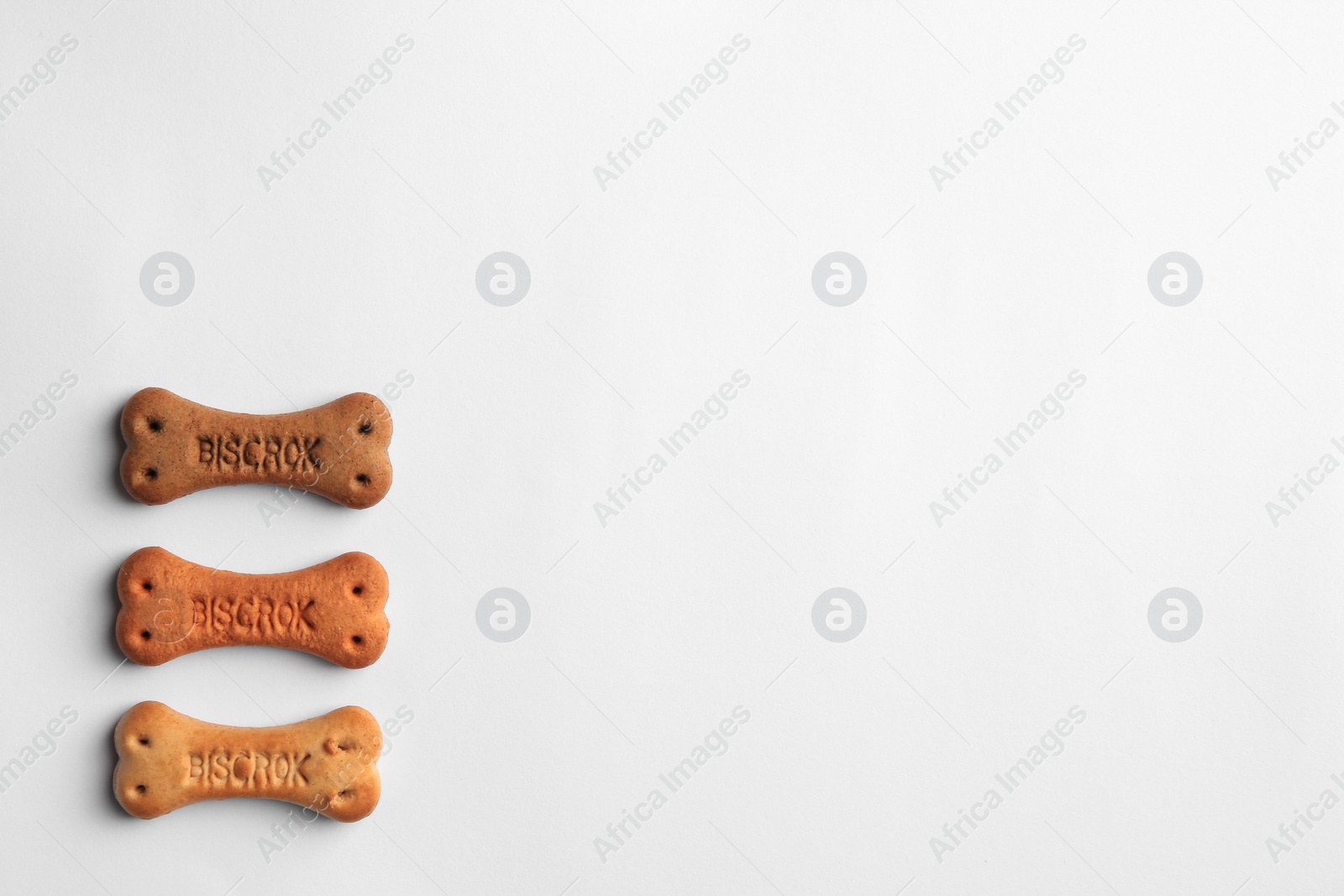 Photo of Bone shaped dog cookies on white background, top view. Space for text