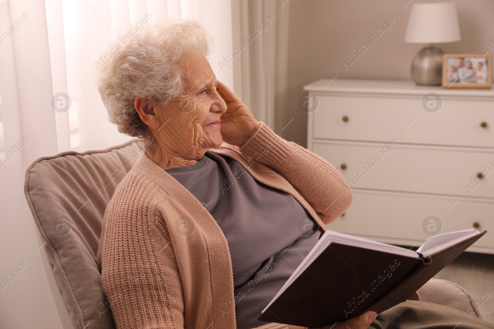 Photo of Senior woman with notebook at home. Age-related memory impairment