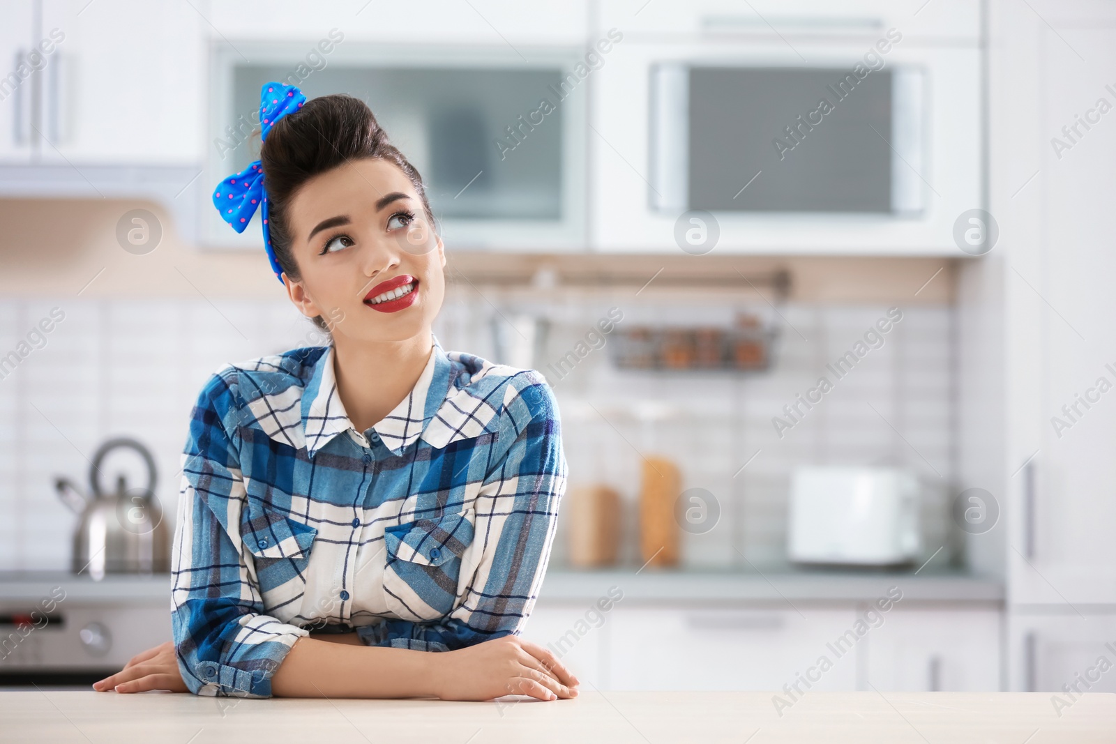 Photo of Portrait of funny young housewife in kitchen