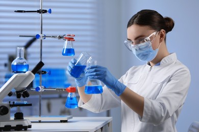 Scientist pouring sample into flask in laboratory