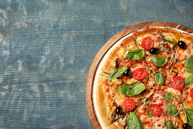 Tasty homemade pizza and space for text on wooden table, top view