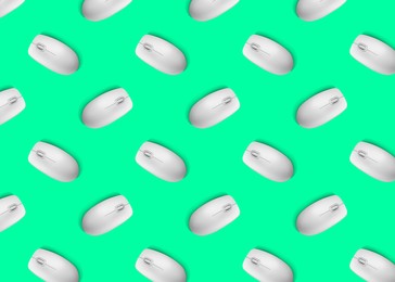 Image of Many white computer mouses on bright green background, flat lay. Seamless pattern design
