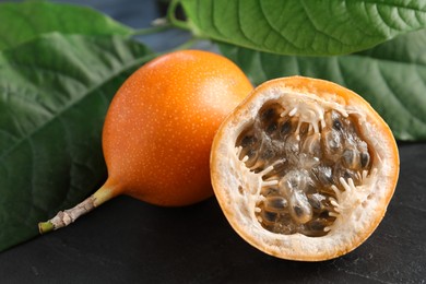 Delicious ripe granadillas on black table, closeup