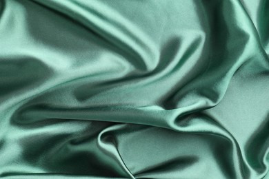 Photo of Crumpled green silk fabric as background, top view