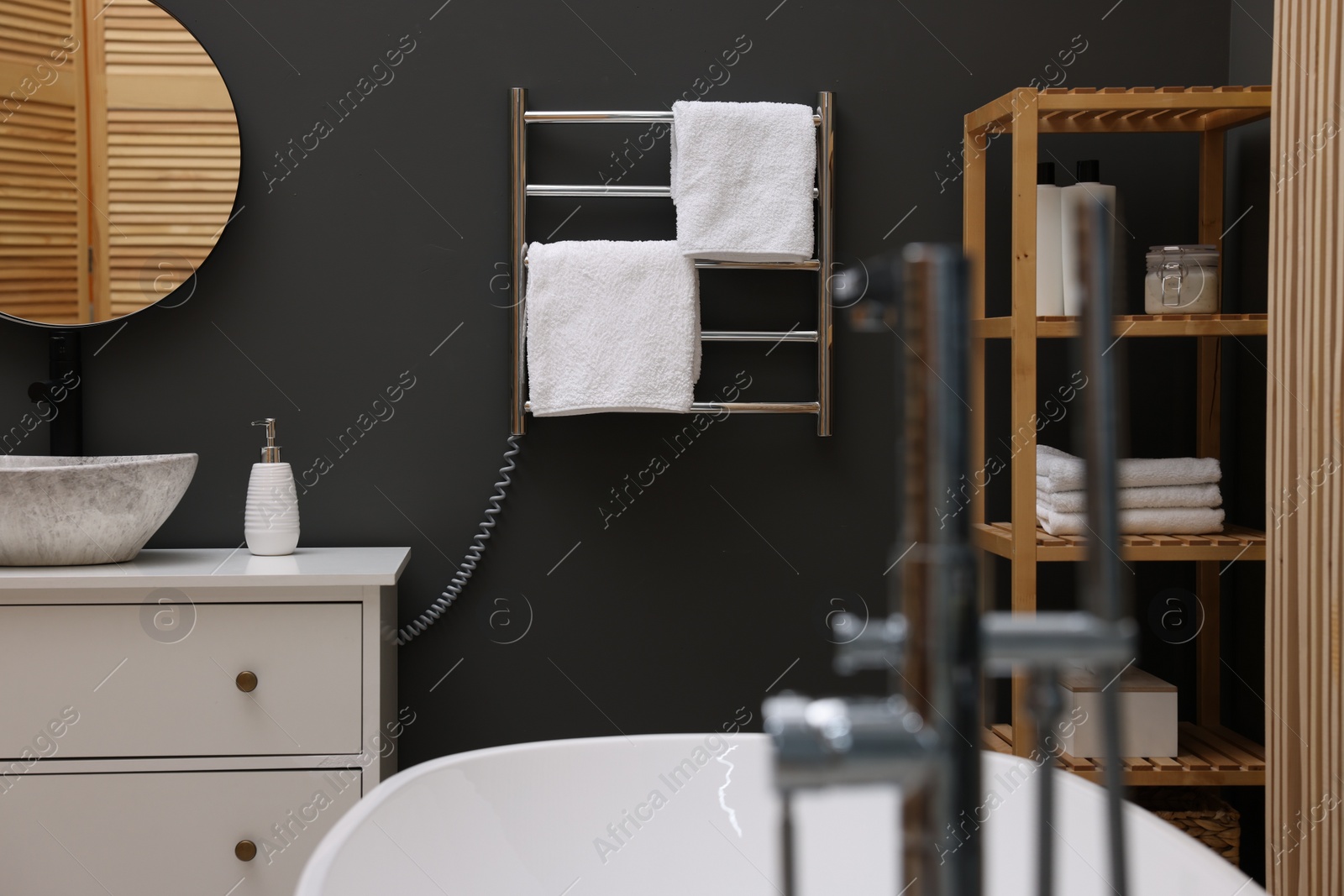 Photo of Stylish bathroom interior with heated towel rail and modern furniture