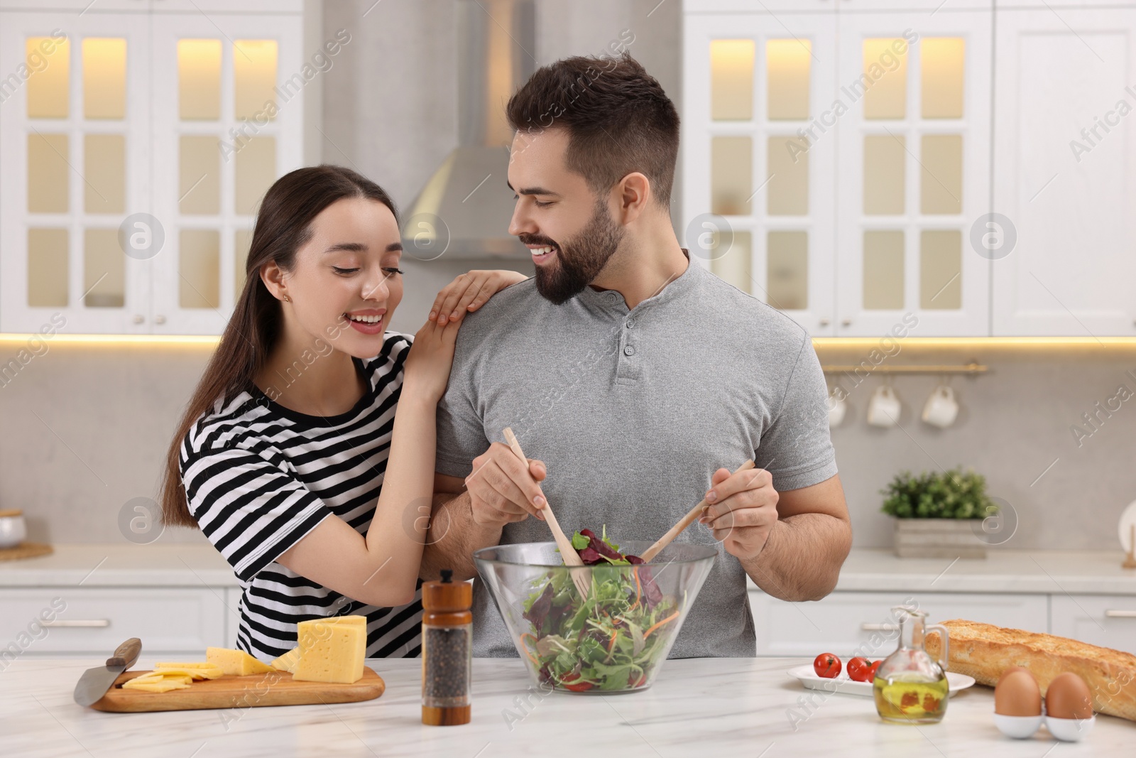 Photo of Lovely young couple cooking together in kitchen