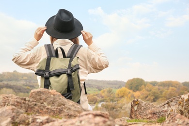 Photo of Traveler with backpack enjoying beautiful view near mountain river. Autumn vacation