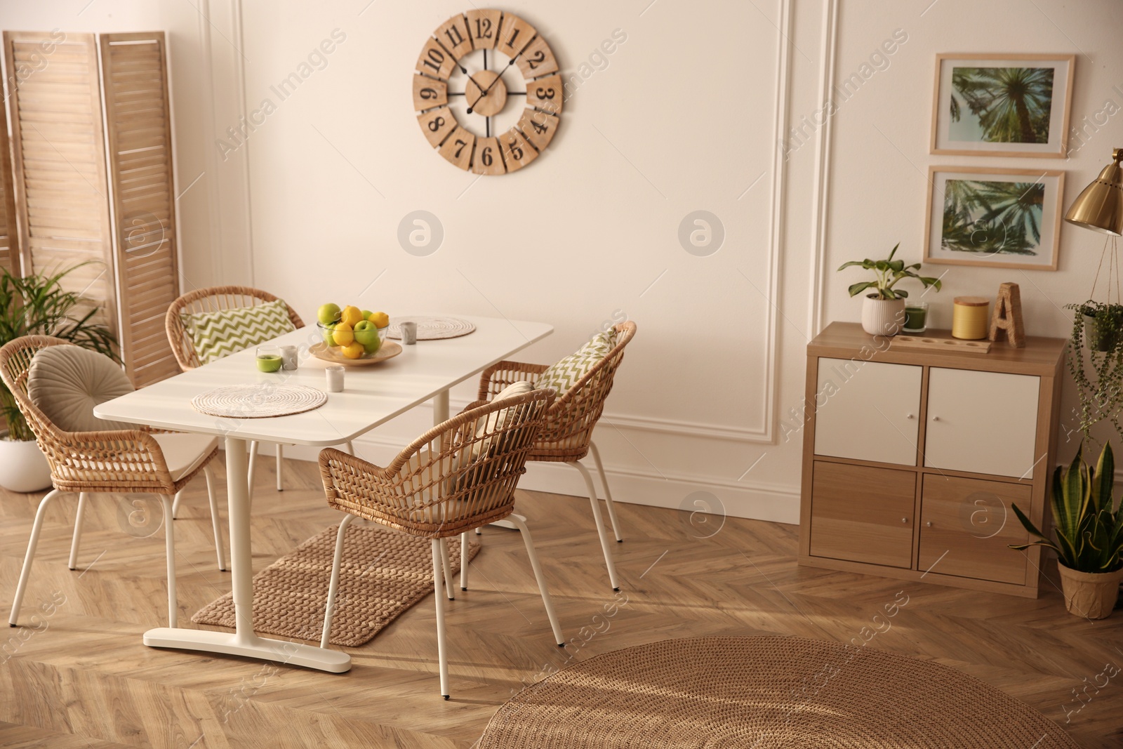 Photo of Stylish white dining table and wicker chairs in room. Interior design