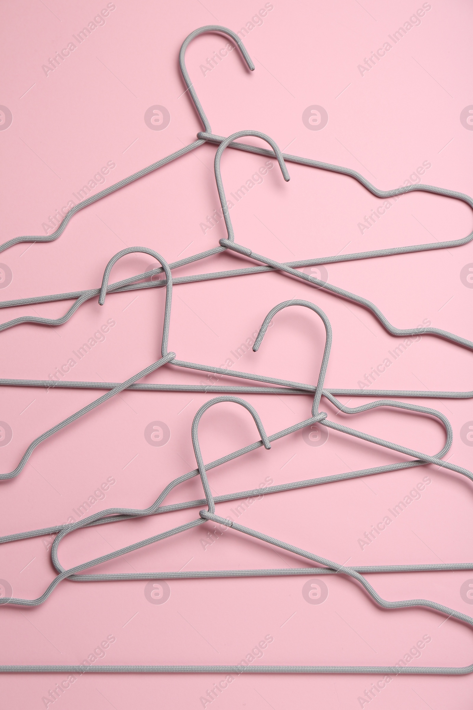 Photo of Many hangers on pink background, flat lay