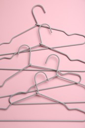 Many hangers on pink background, flat lay