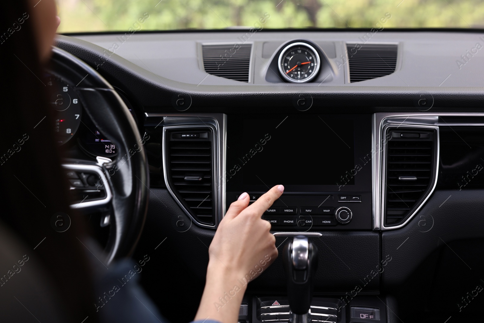 Photo of Woman using navigation system while driving her car, closeup