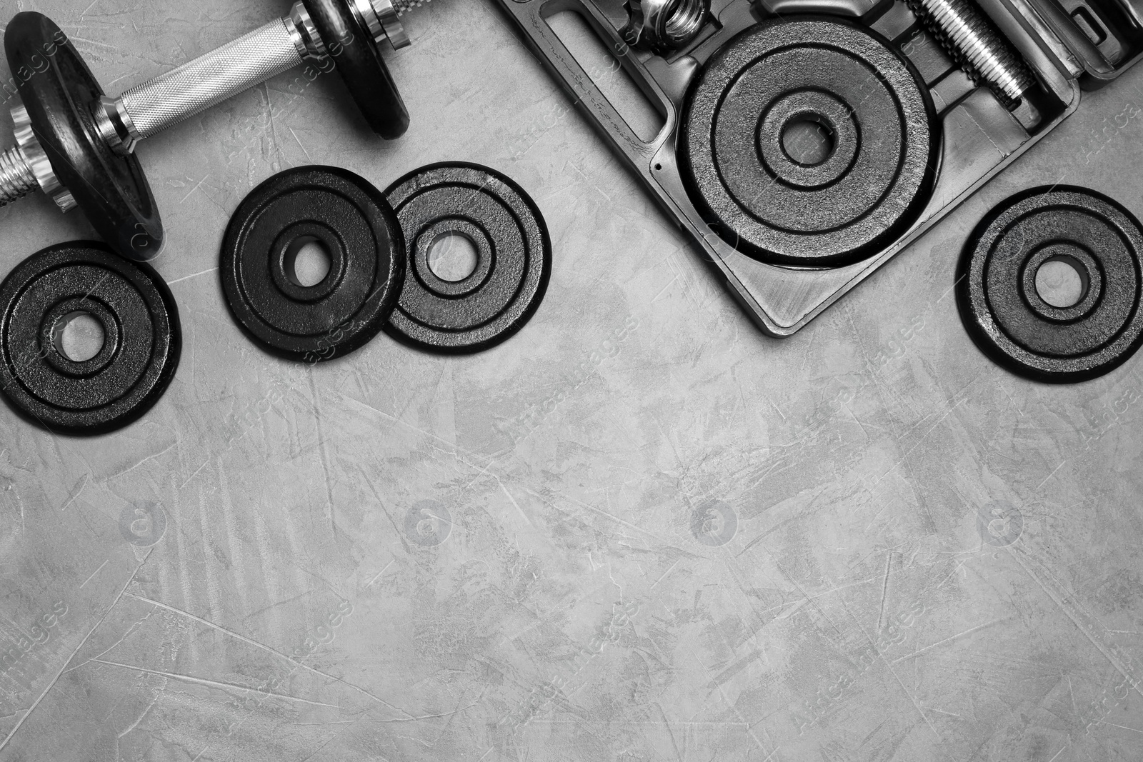 Photo of Flat lay composition with dumbbell and space for text on gray background