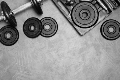 Photo of Flat lay composition with dumbbell and space for text on gray background