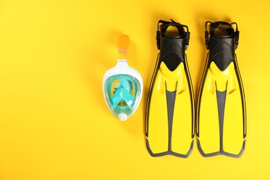 Photo of Swimming flippers and mask on color background, top view. Space for text