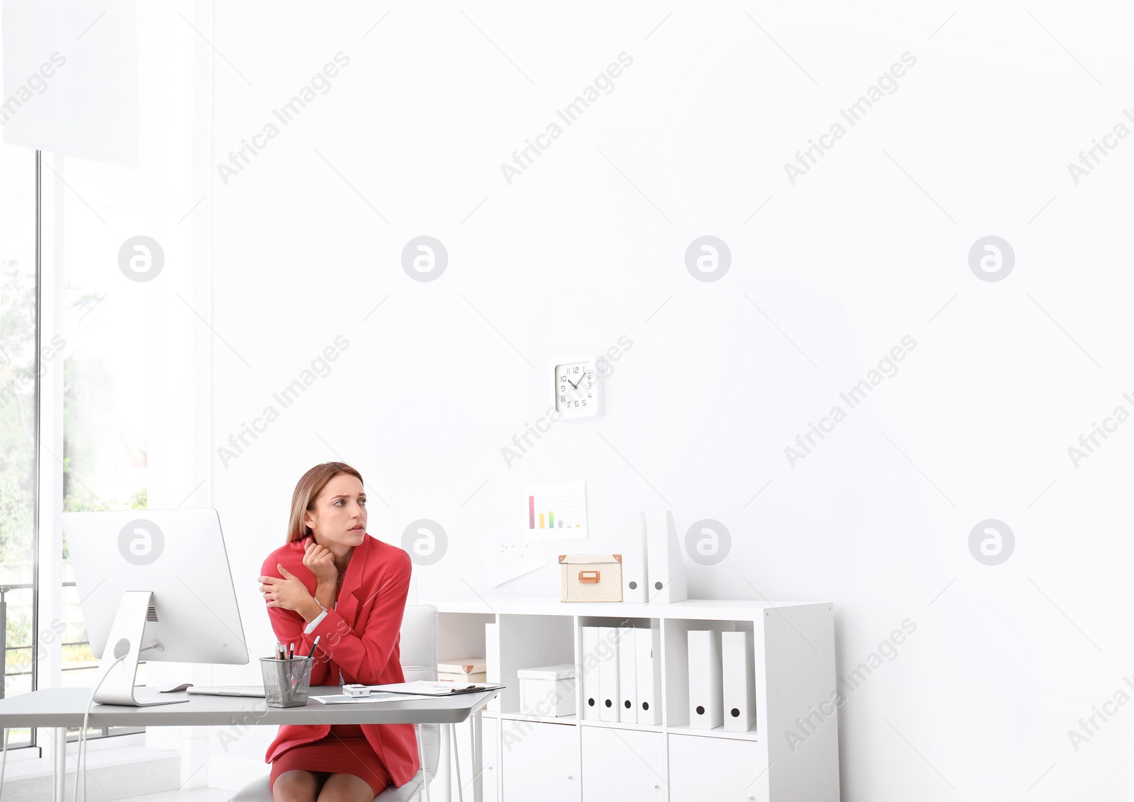 Photo of Young woman freezing under air conditioner in office