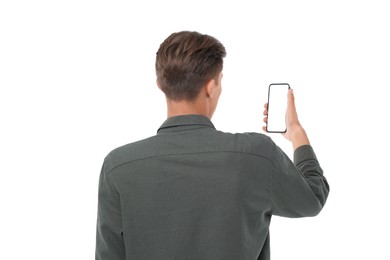 Man holding phone with blank screen on white background, back view. Mockup for design