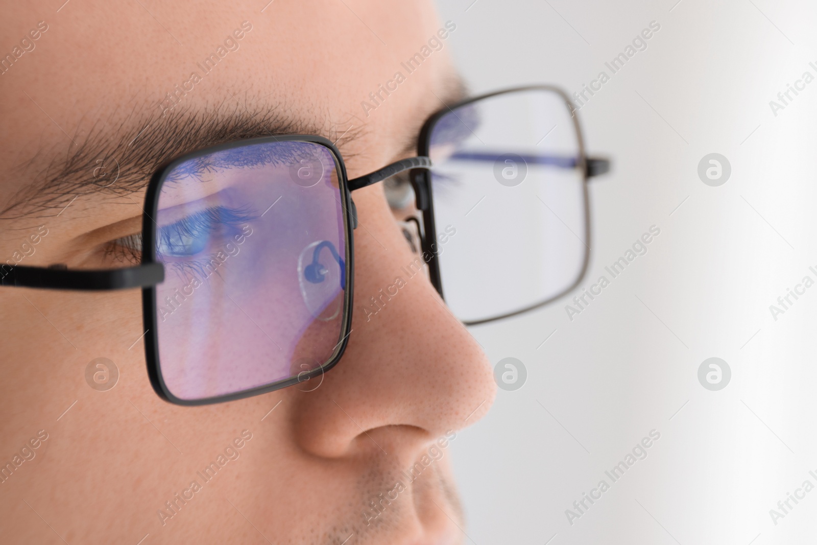 Photo of Man wearing glasses on light background, closeup