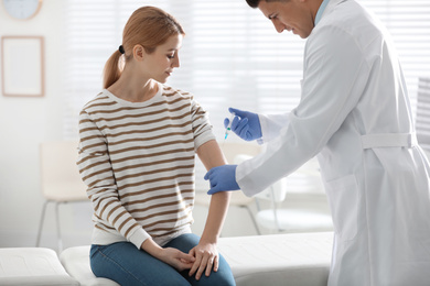 Doctor giving injection to patient in hospital. Vaccination concept