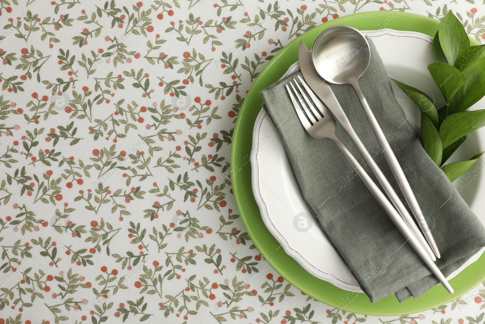 Photo of Stylish setting with cutlery, plates, napkin and floral decor on table, top view. Space for text