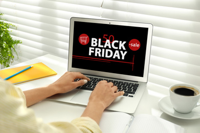 Image of Black Friday. Woman shopping online using laptop at table, closeup