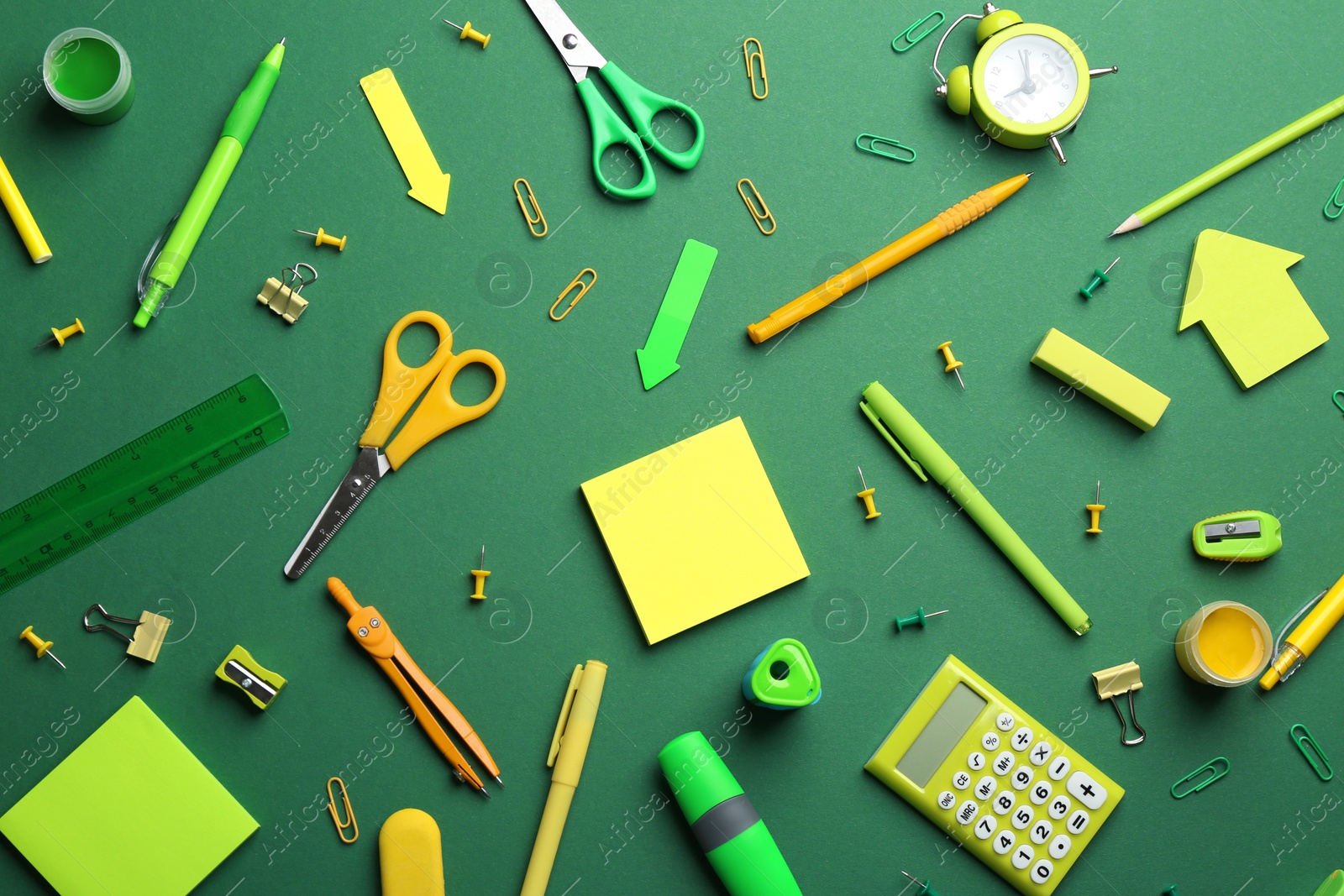 Photo of Bright school stationery on green background, flat lay