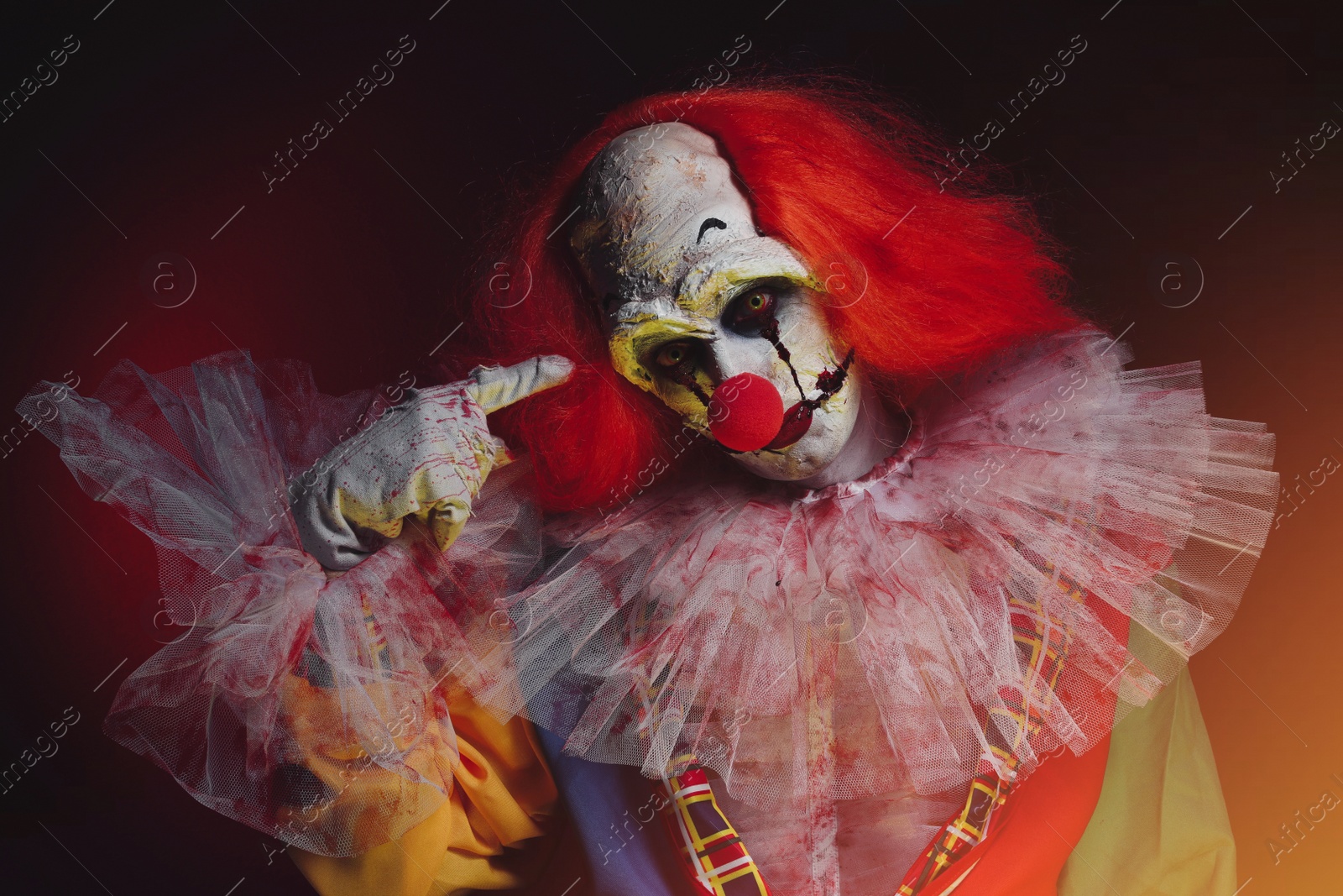 Photo of Terrifying clown in darkness. Halloween party costume