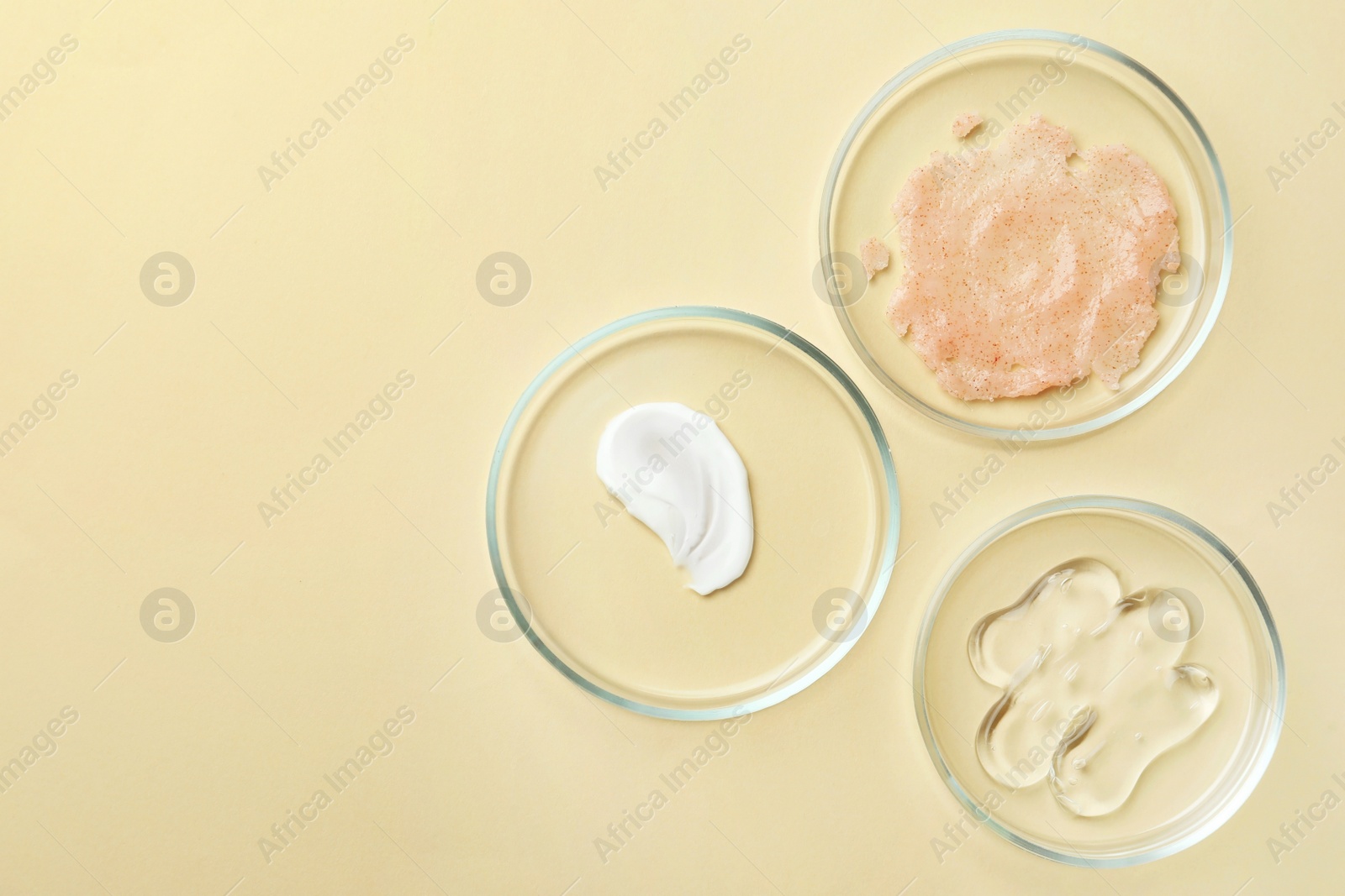 Photo of Many Petri dishes and cosmetic products on beige background, flat lay. Space for text