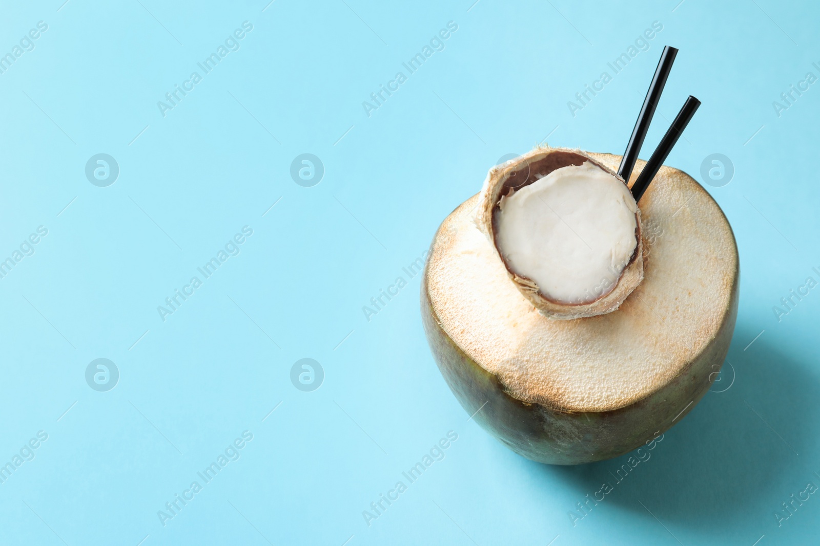 Photo of Fresh green coconut with drinking straws on color background