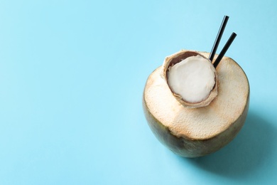 Photo of Fresh green coconut with drinking straws on color background