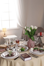 Photo of Festive Passover table setting with Torah at home. Pesach celebration