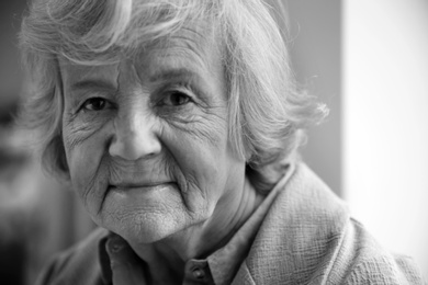 Photo of Portrait of elderly woman indoors. Black and white effect