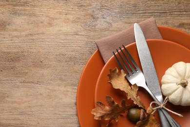 Photo of Festive table setting with autumn decor on wooden background, top view. Space for text