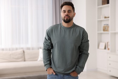 Handsome man in stylish sweater at home