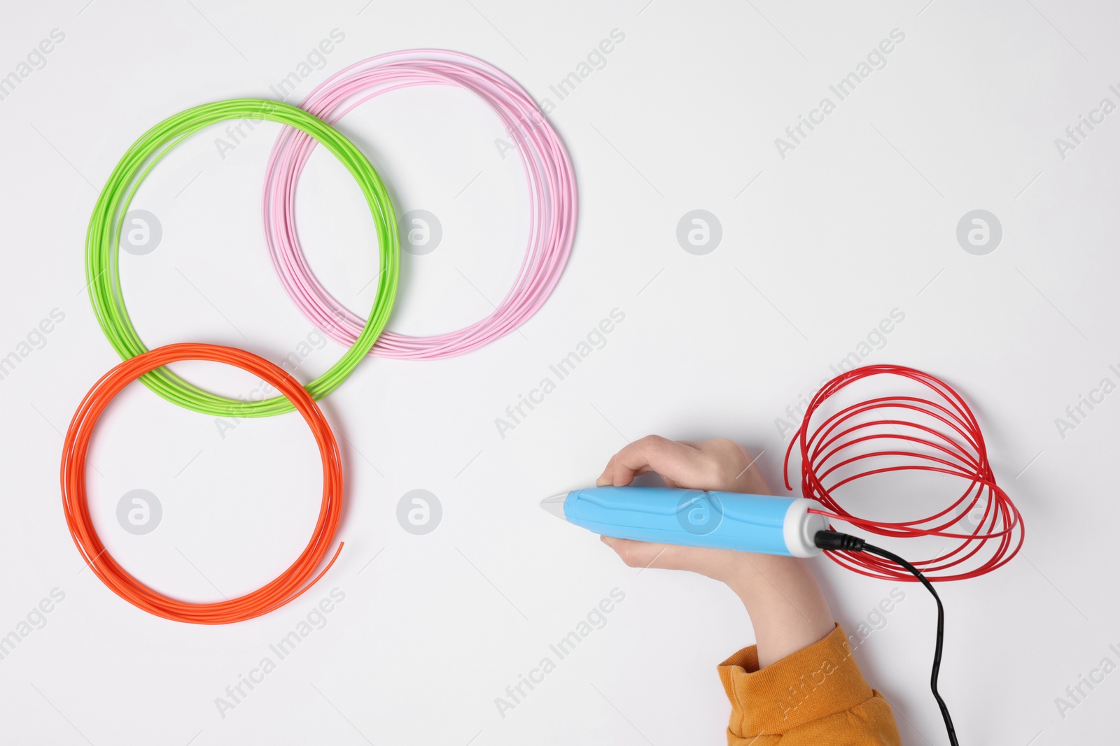 Photo of Boy drawing with stylish 3D pen on white background, top view