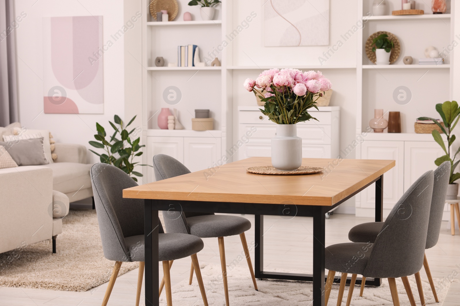 Photo of Stylish dining room with cosy furniture and flowers