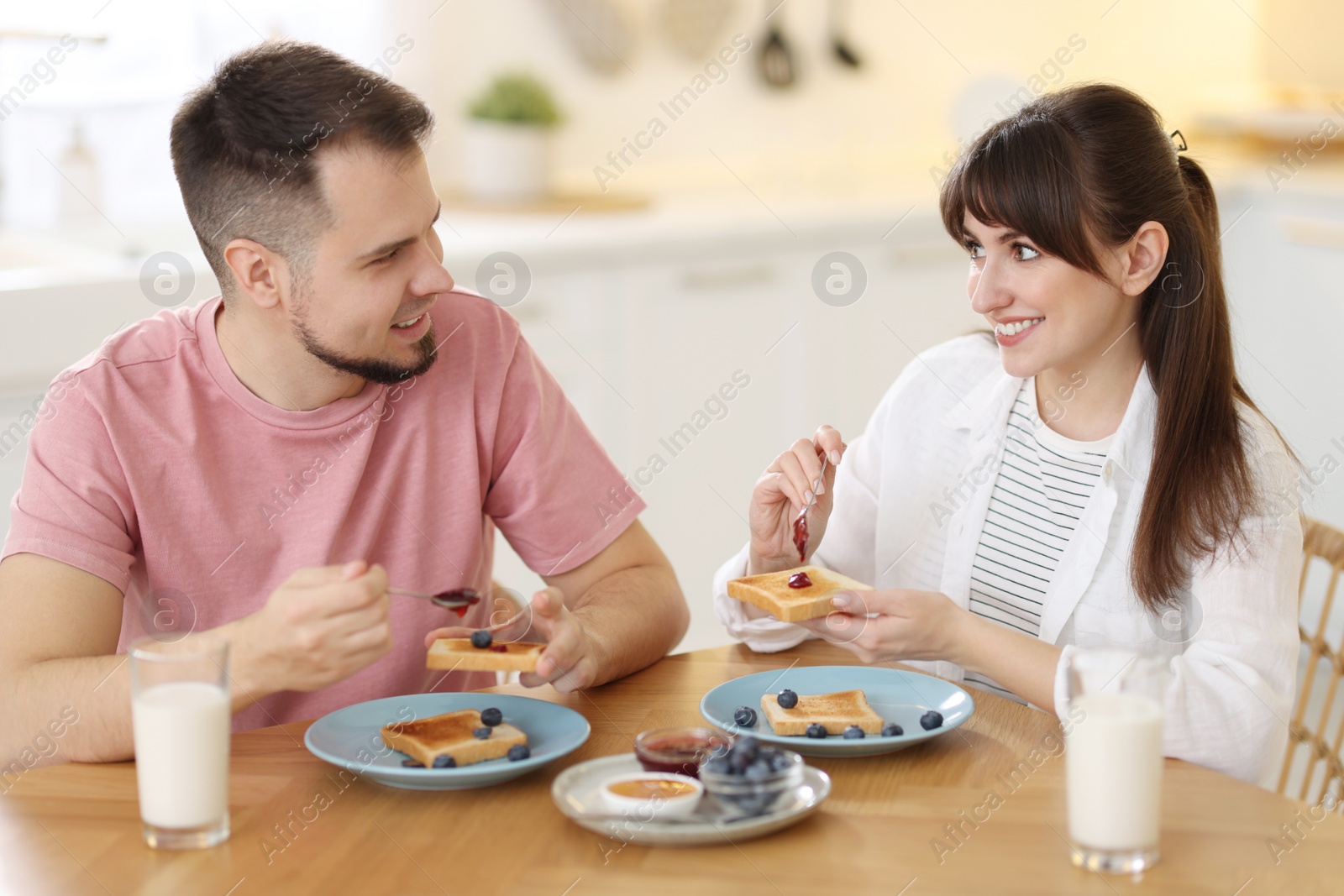 Photo of Happy couple having tasty breakfast at home