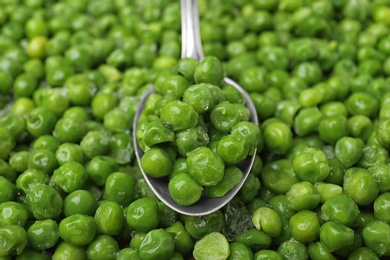 Photo of Spoon and frozen peas, closeup. Vegetable preservation