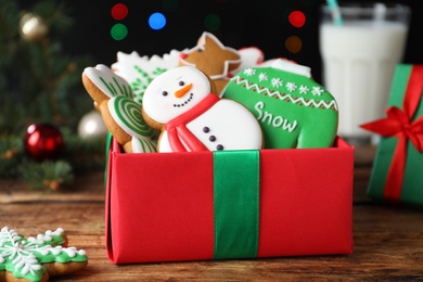 Photo of Tasty Christmas cookies in gift box on wooden table, closeup