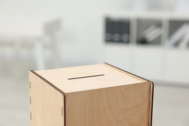 Photo of Wooden ballot box on blurred background, closeup. Space for text