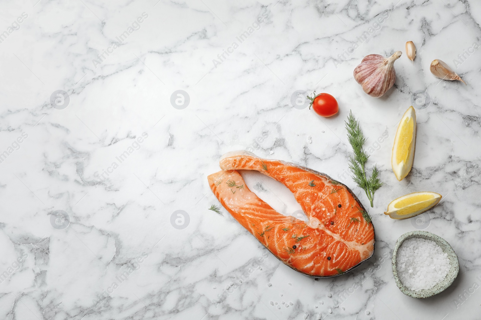 Photo of Fresh raw salmon steak and seasonings on marble background, top view