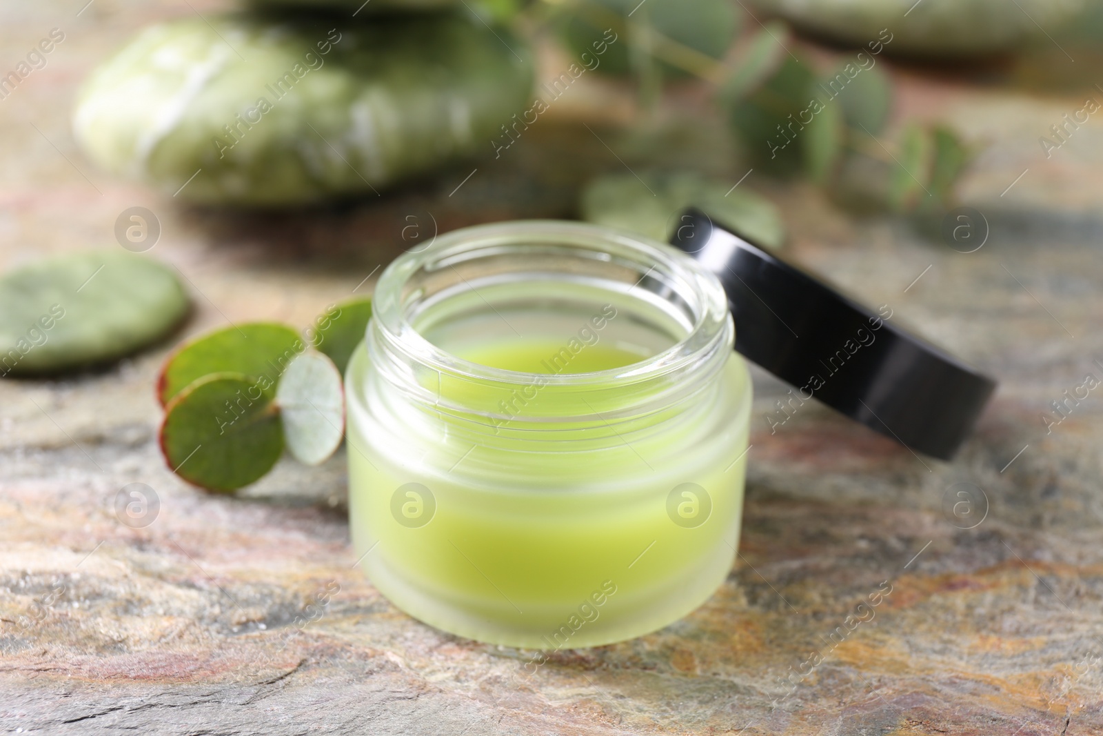 Photo of Jar of cream on textured table, closeup. Body care product