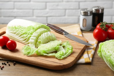 Photo of Cut fresh Chinese cabbage, tomatoes and spices on wooden table